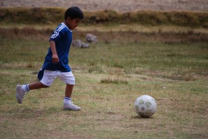 A Boy Playing Soccer in Sacsayhuamanq